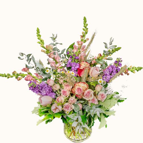 Multicoloured 'Garden Romance' flowers in a small glass vase